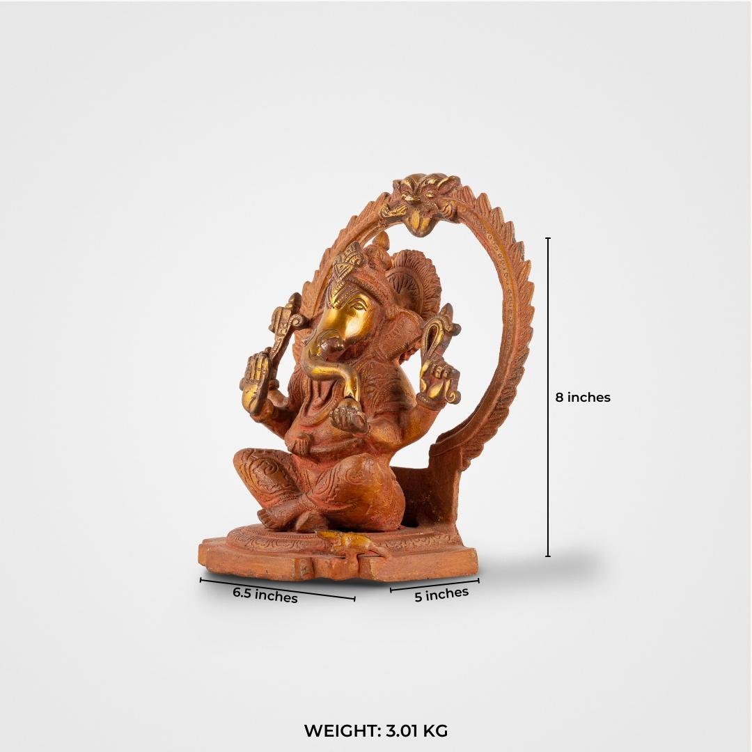 Red Oxidised Brass Ganesha Statue framed by a swirling halo on a home altar. 