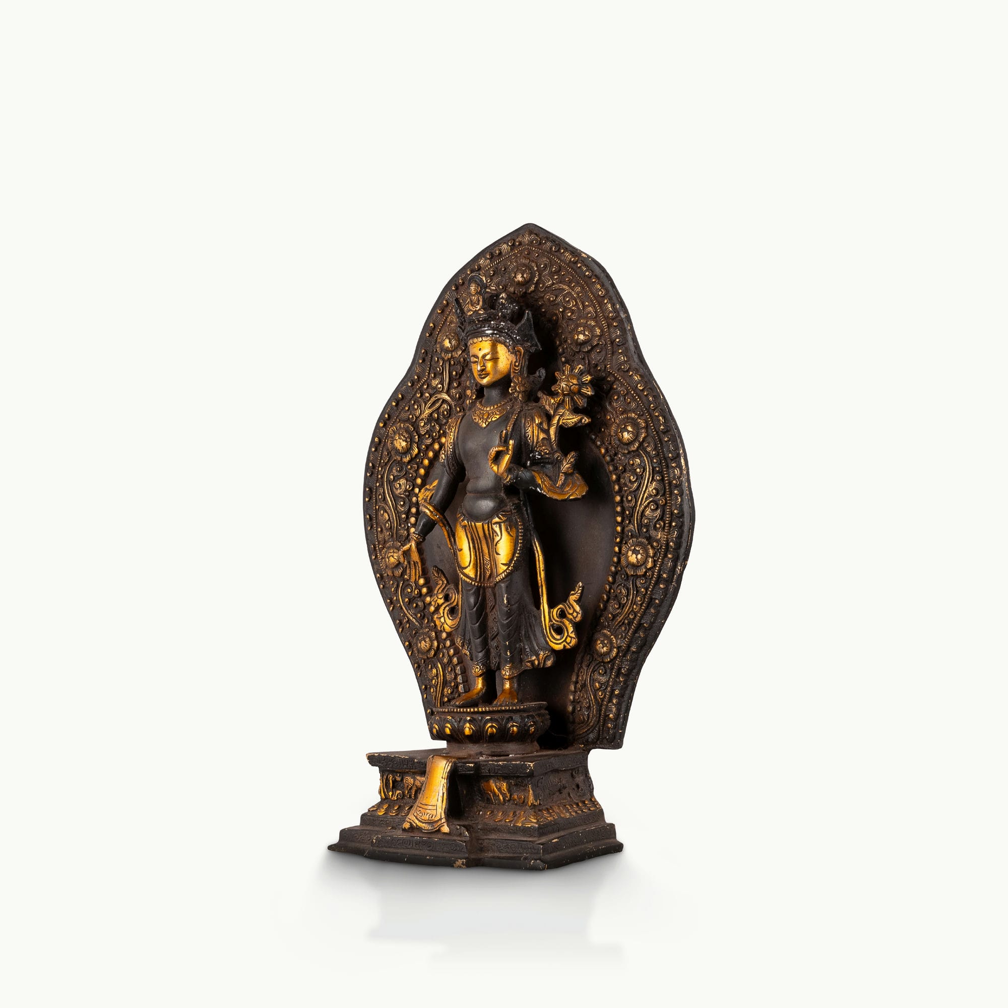 Black Oxidized Standing Tara Statue framed by a golden aureole for a home altar.