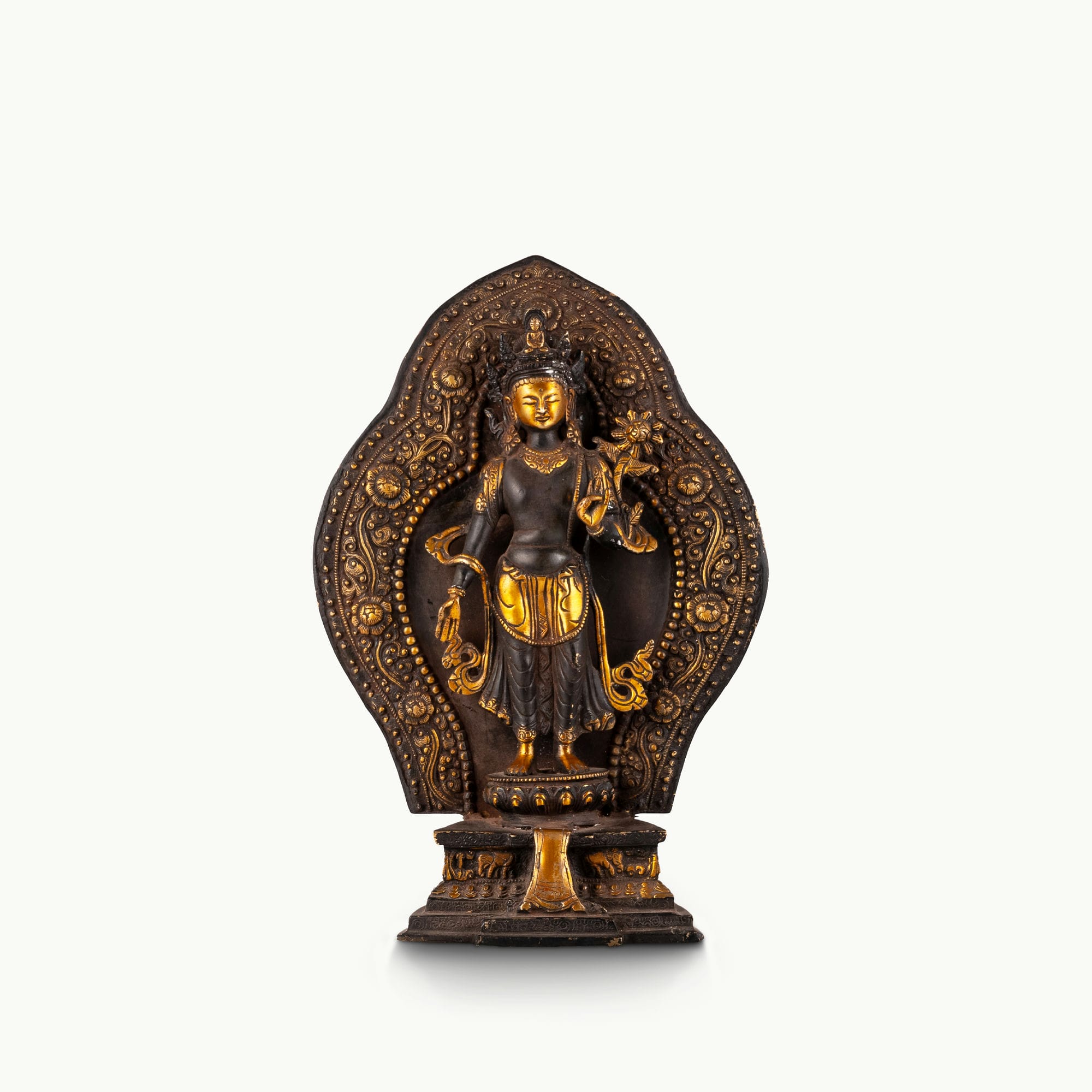 Black Oxidized Standing Tara Statue framed by a golden aureole for a home altar.