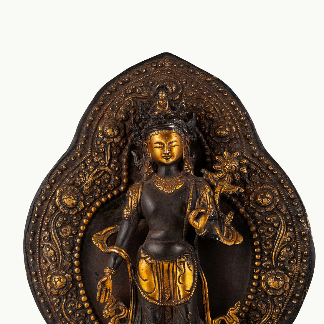 Black Oxidized Standing Tara Statue framed by a golden aureole for a home altar.