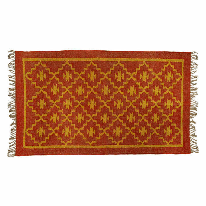 Red geometric flatweave dhurrie in a living room, highlighting intricate golden-yellow diamonds. 
