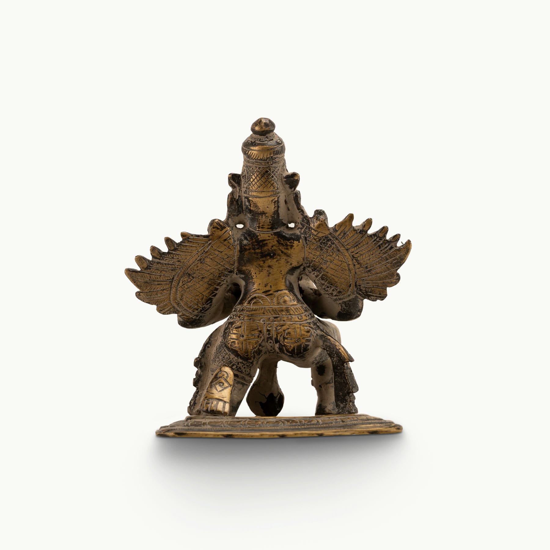 Antique Brass Garuda Statue kneeling in eternal devotion on a home altar. 