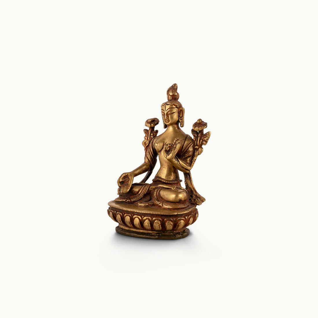 Polished Brass Tara Statue emerging from stylized lotus petals on a bedside table. 