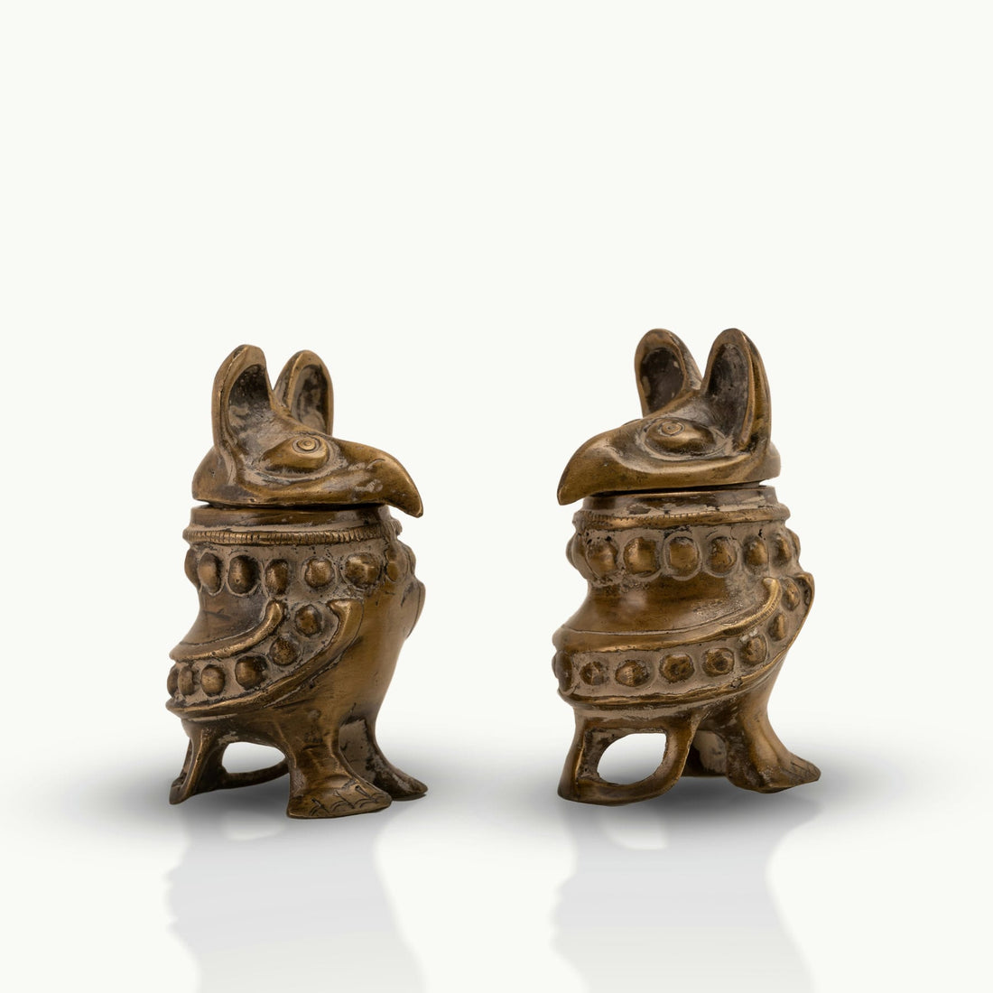 Antique Brass Bird Boxes concealing small inner chambers on a mirrored dressing table. 