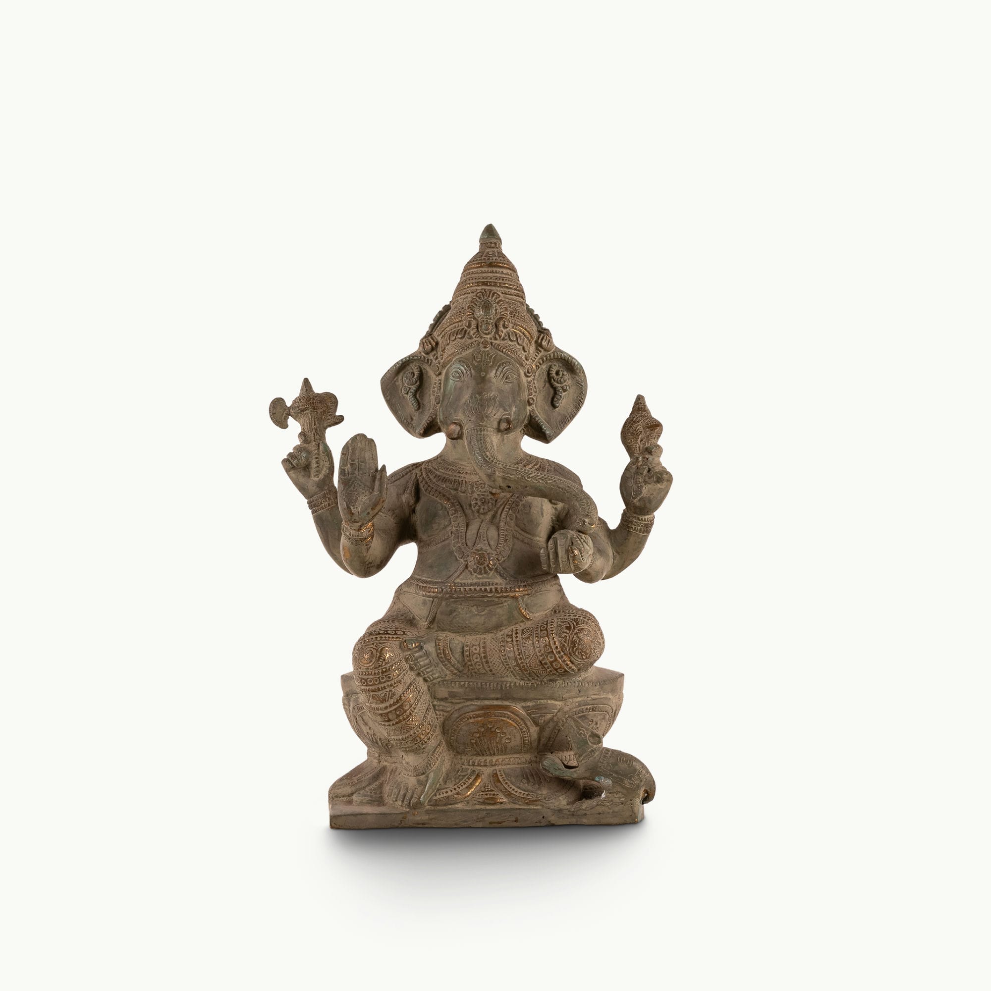 Distressed Brass Ganesha Statue sitting in a regal posture on an east-facing home altar. 