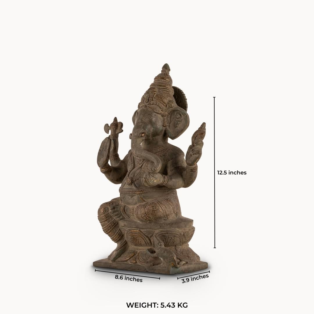 Distressed Brass Ganesha Statue sitting in a regal posture on an east-facing home altar. 