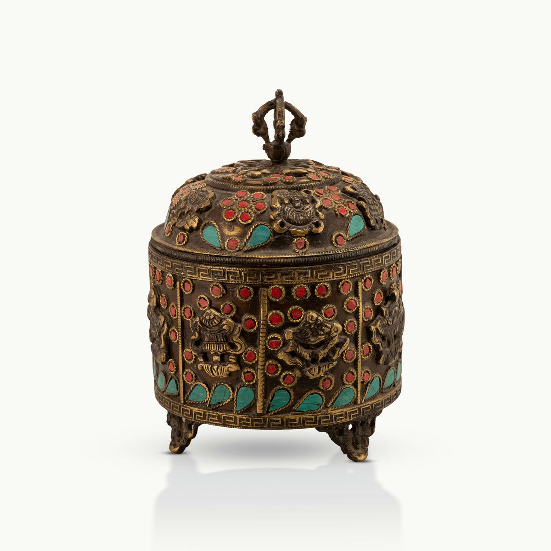 Stone Inlay Brass Vajra Box topped with a spiritual finial on an open bookshelf. 