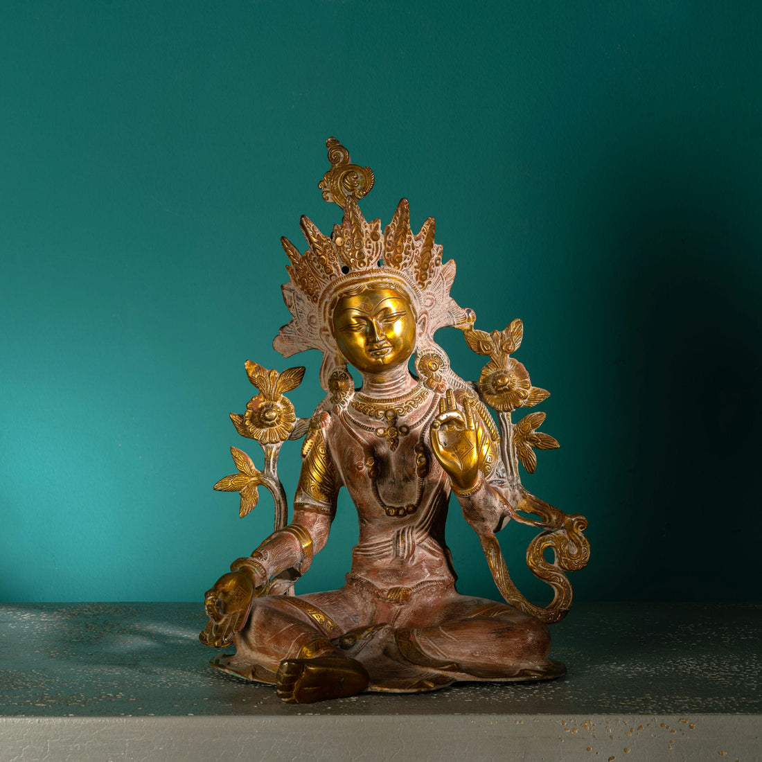 Handcrafted metal Buddhist goddess sculpture with polished golden highlights for a meditation space or spiritual sanctuary.