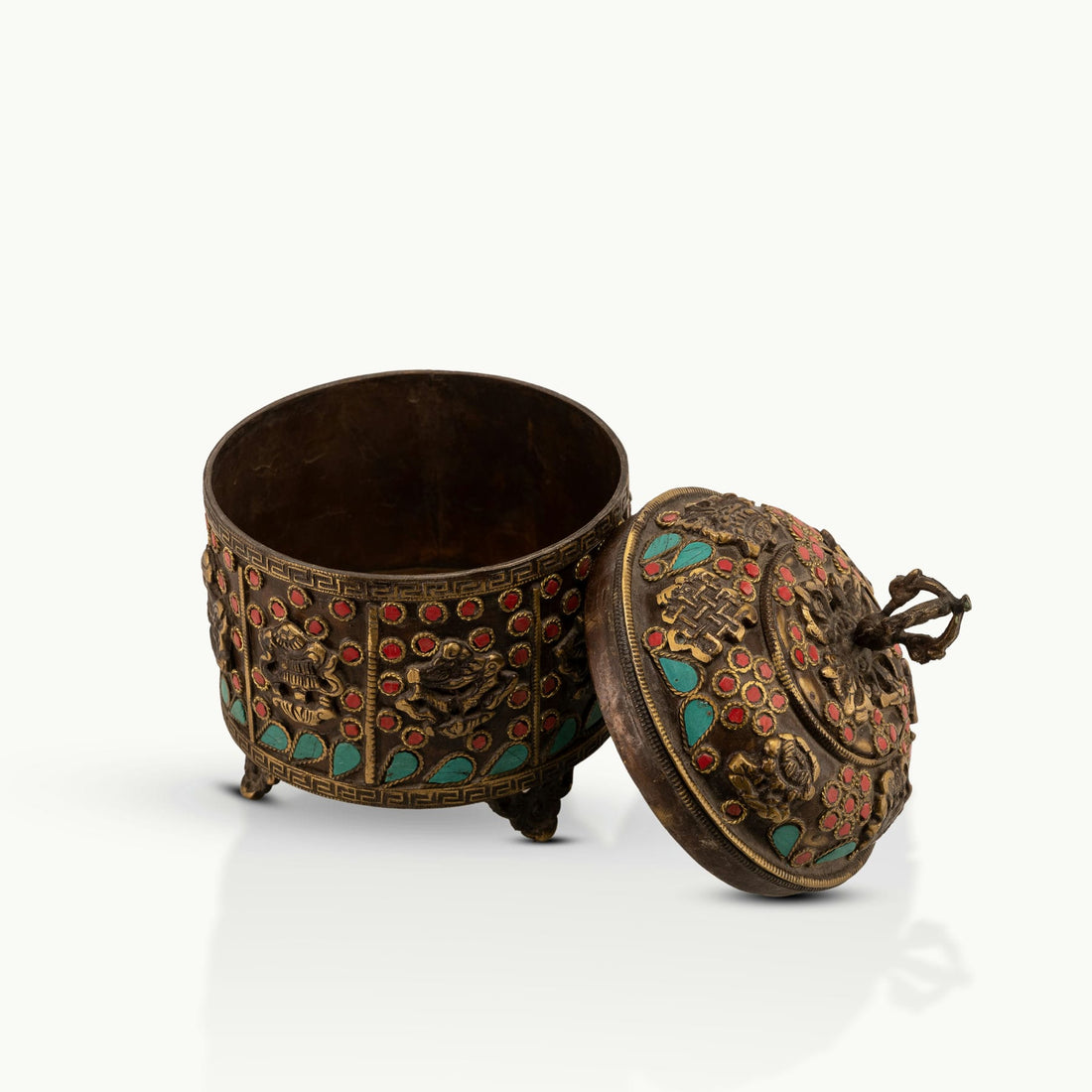 Stone Inlay Brass Vajra Box topped with a spiritual finial on an open bookshelf. 