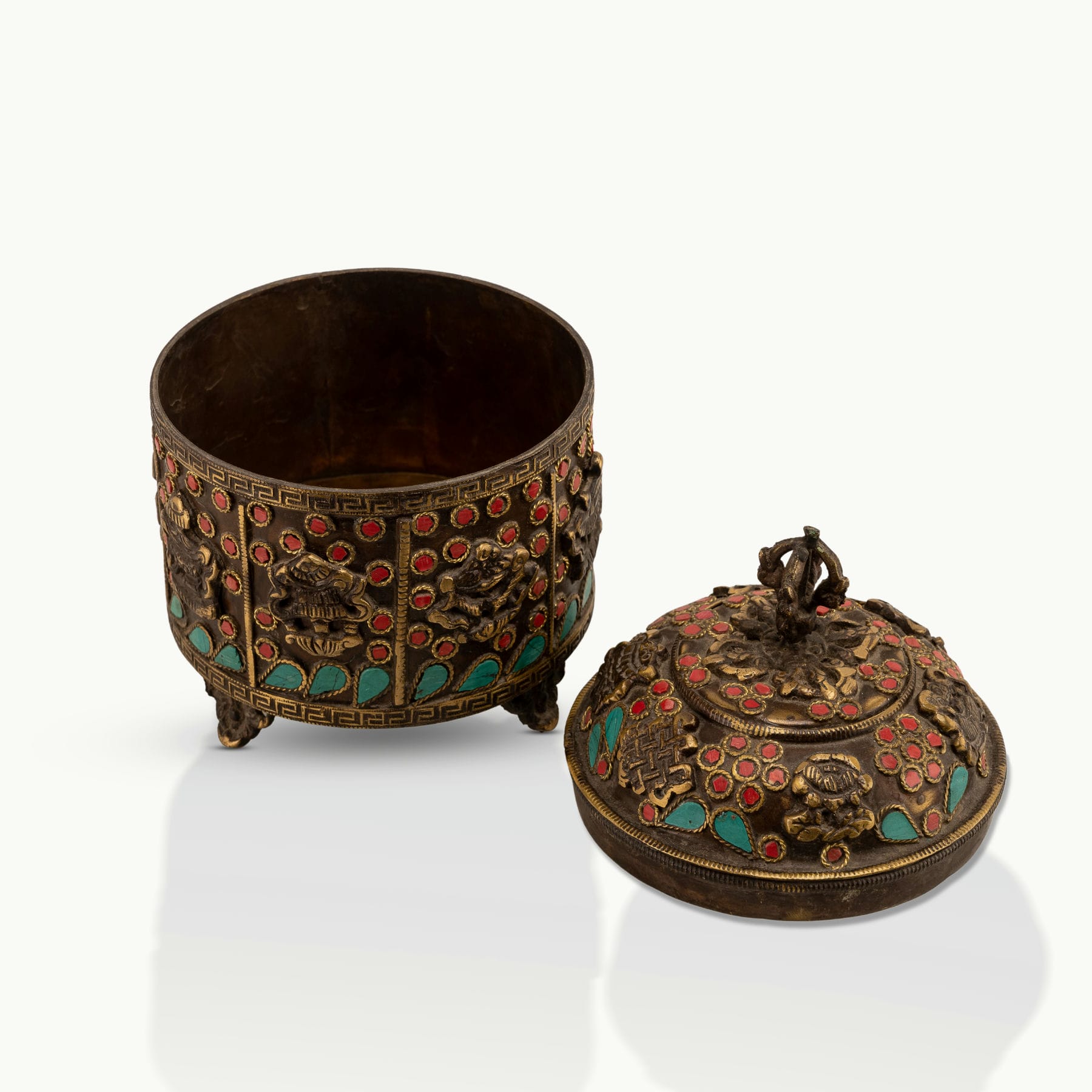 Stone Inlay Brass Vajra Box topped with a spiritual finial on an open bookshelf. 