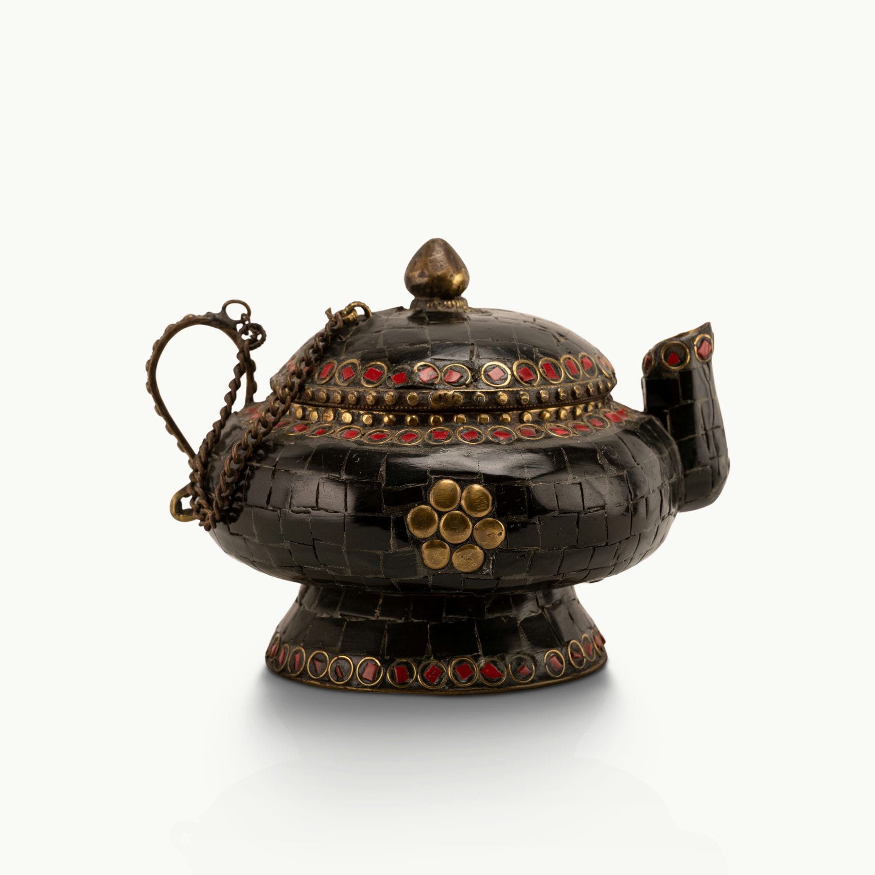 Black Stone Inlay Brass Teapot accented with ruby-red details on a dark walnut sideboard. 