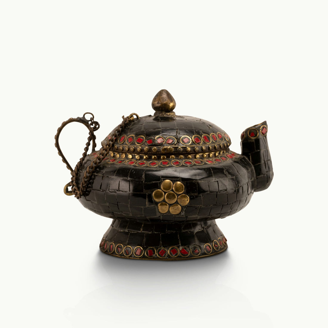 Black Stone Inlay Brass Teapot accented with ruby-red details on a dark walnut sideboard. 
