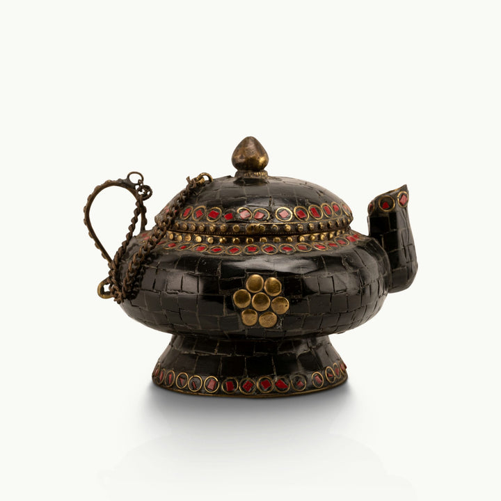 Black Stone Inlay Brass Teapot accented with ruby-red details on a dark walnut sideboard. 