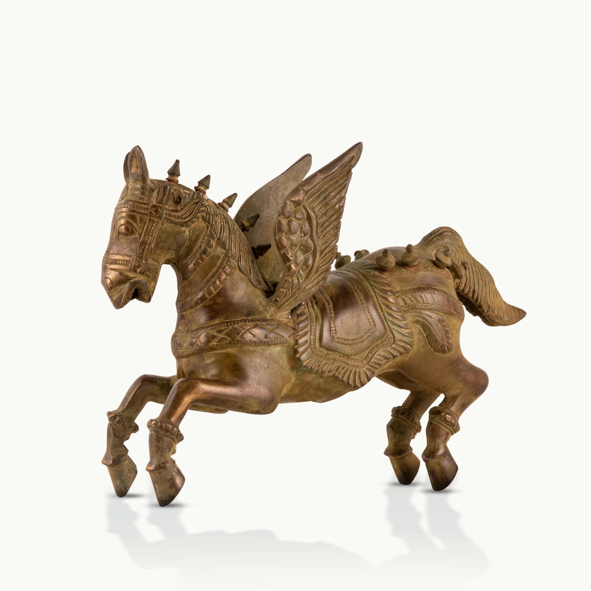 Brass Winged Horse Sculpture captured in a dynamic prancing gallop on a home library console. 