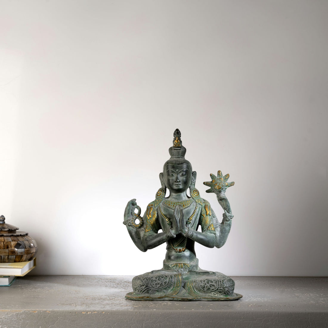 Handcrafted verdigris metal Bodhisattva decor sitting in padmasana for a private study or zen space.