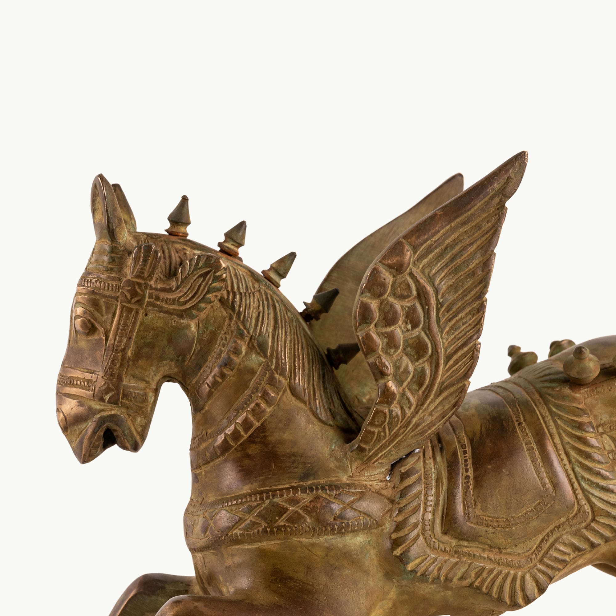 Brass Winged Horse Sculpture captured in a dynamic prancing gallop on a home library console. 