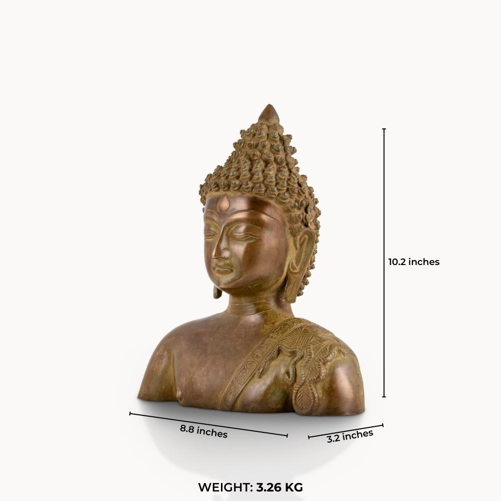 Antique brass Buddha bust featuring a serene face and an engraved robe.