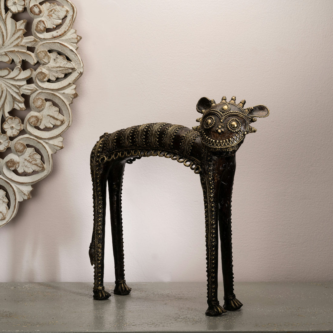 Dhokra Brass Tribal Feline Sculpture staring fiercely on a minimalist concrete credenza. 
