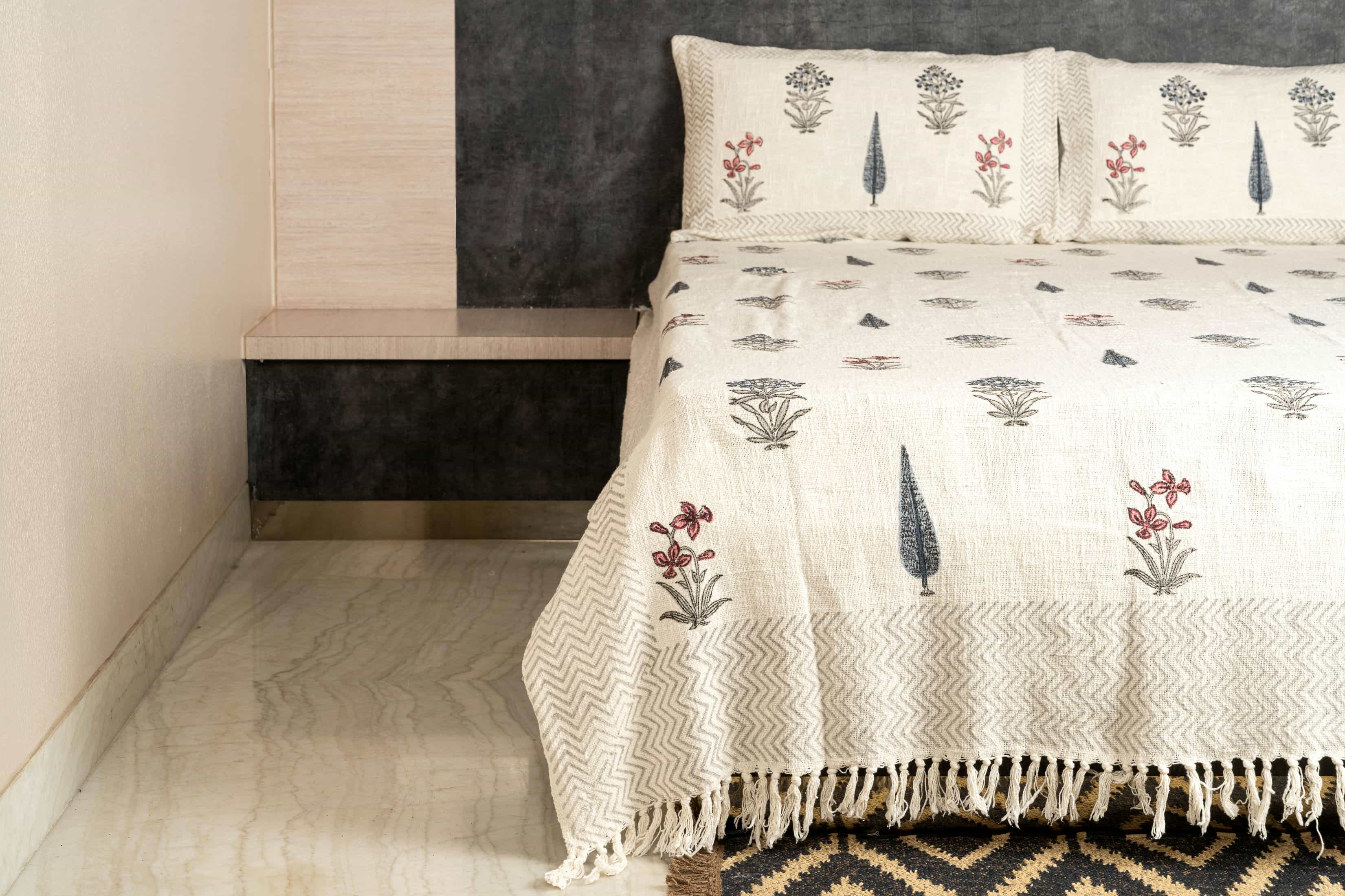 Hand-block printed cotton coverlet with scattered poppy and cypress motifs