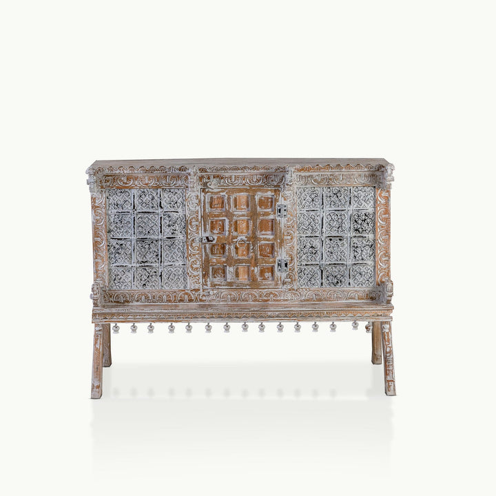Whitewashed carved mango wood console featuring a stamped metal facade and botanical borders.