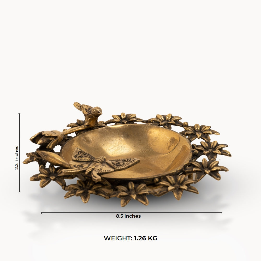 Antique Brass Floral Decorative Bowl framed by sculpted wildlife on an entryway table. 
