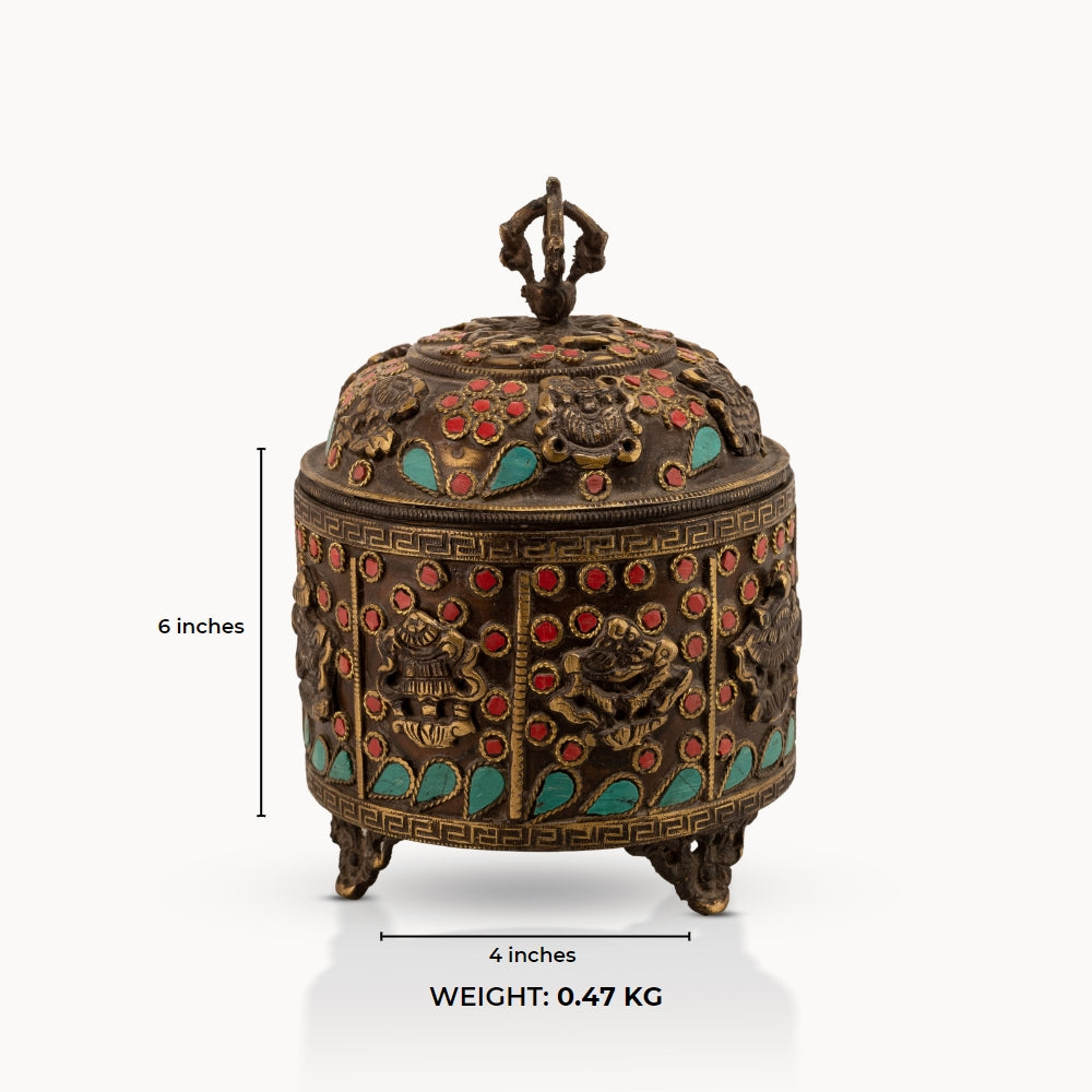 Stone Inlay Brass Vajra Box topped with a spiritual finial on an open bookshelf. 