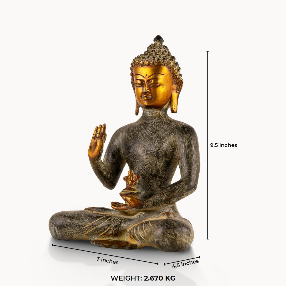 Etched Brass Abhaya Buddha Statue resting in the Padmasana posture on a low natural-edge wooden altar. 