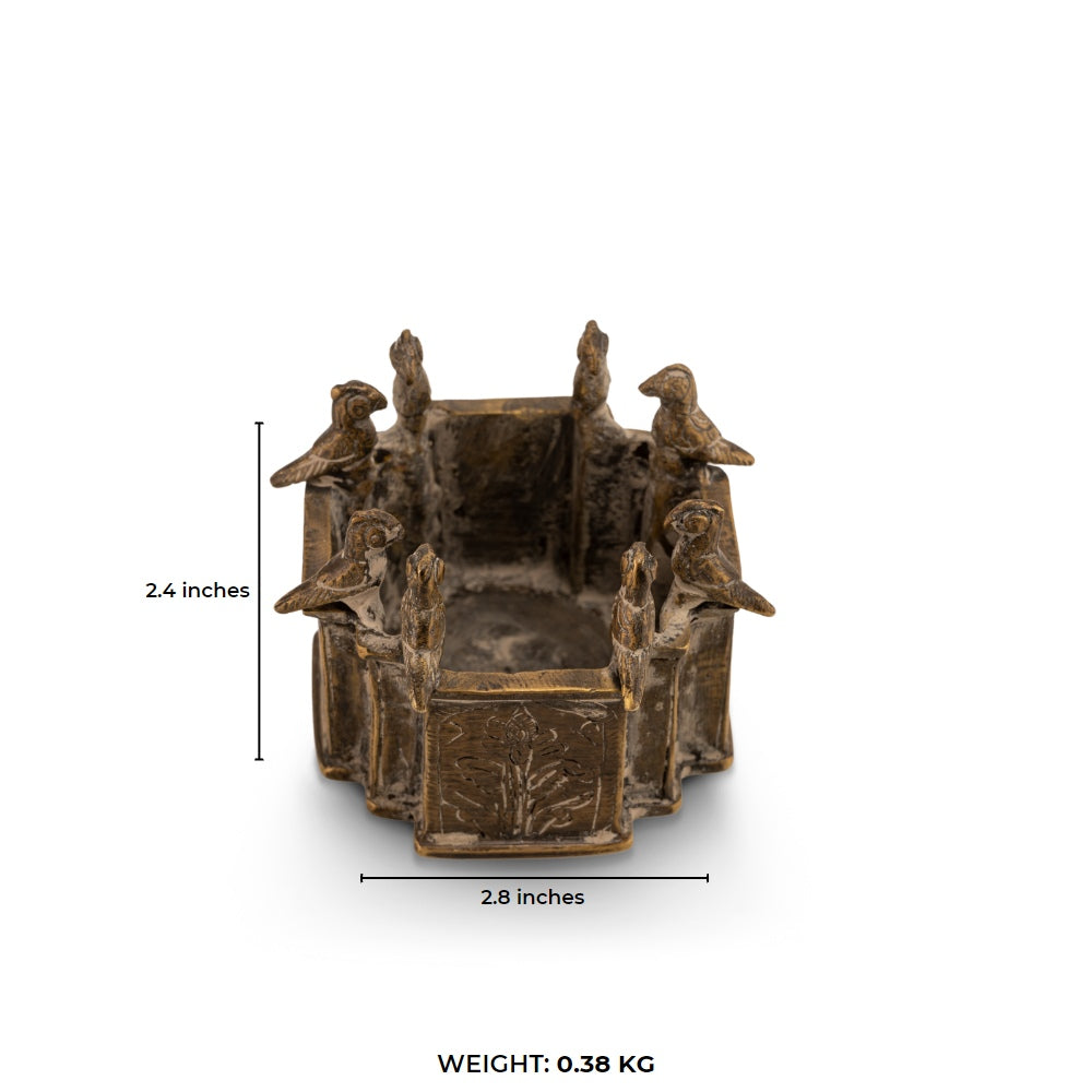 Engraved Brass Bird Vessel bordered by miniature avian sentinels on a study desk. 
