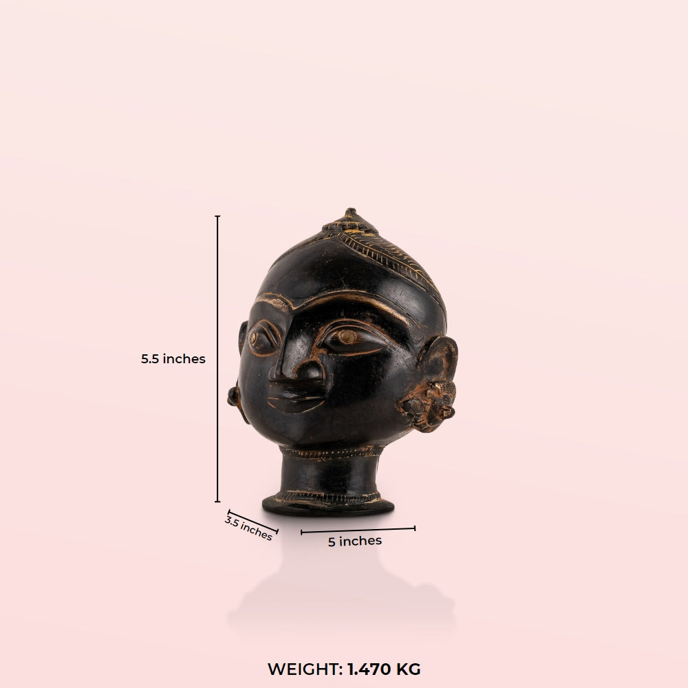 Black Brass Tribal Head Sculpture projecting an ancestral presence on a floating gallery shelf. 